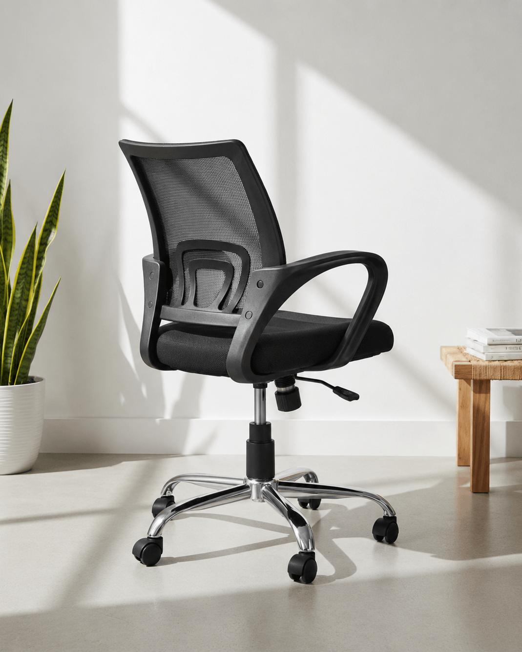 Back view of black mid-back ergonomic office revolving chair with cushioned seat and nylon swivel base with castors – Blaze MB by Kazuri
