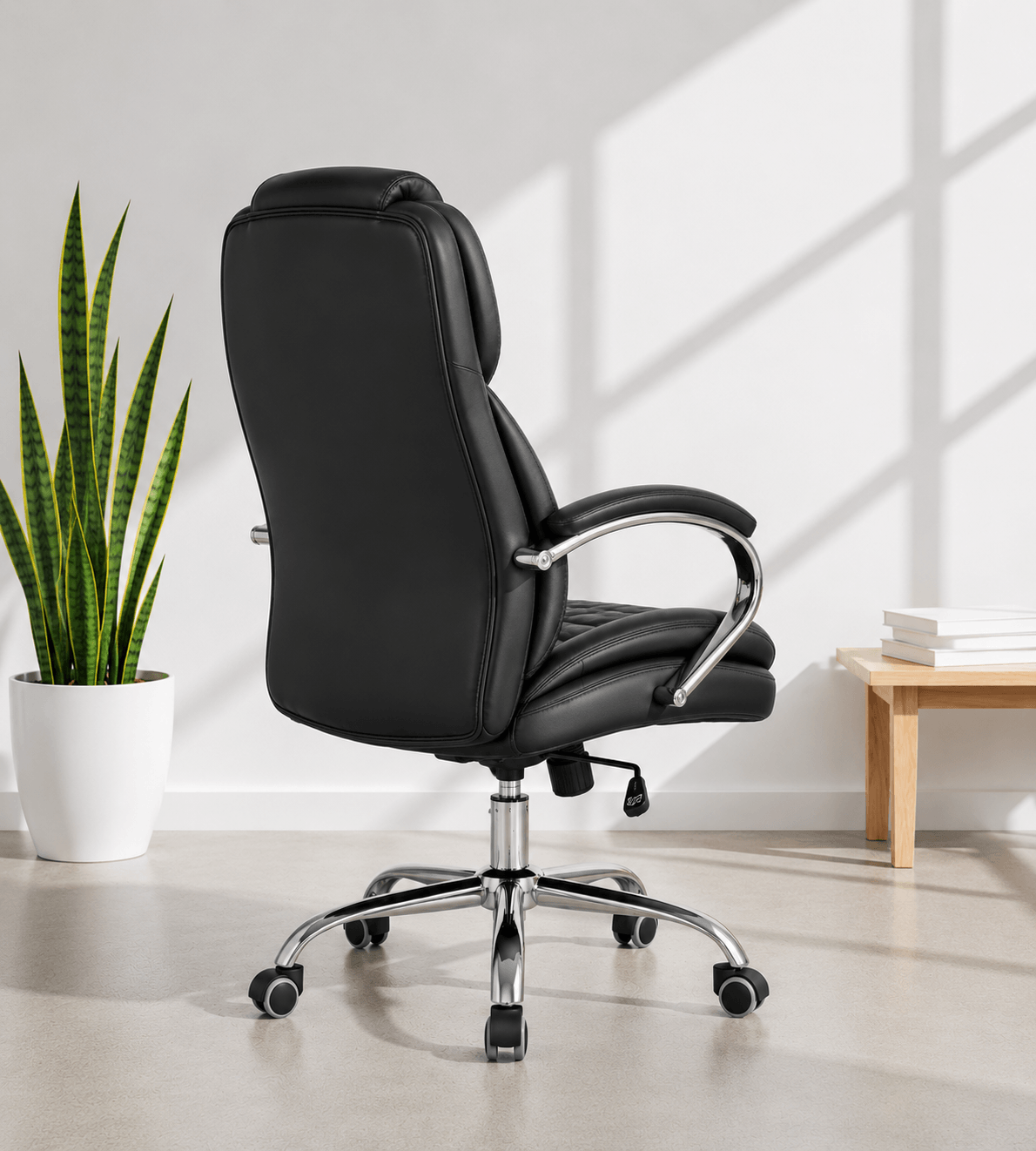 Back view of black high-back executive cushioned revolving office chair with quilted back, integrated headrest, padded chrome armrests and chrome five-star swivel base – Galaxy HB by Kazuri