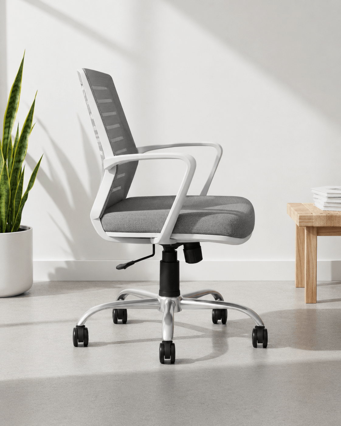 Side view of grey mid-back mesh revolving office chair with cushioned seat, fixed armrests and nylon swivel base with castors – Tom MB by Kazuri
